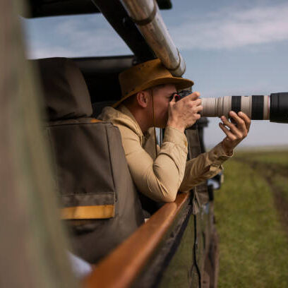 Expert photographer capturing animals on a Tanzania safari with his mirrorless camera Expert photographer capturing animals on a Tanzania safari with his mirrorless camera