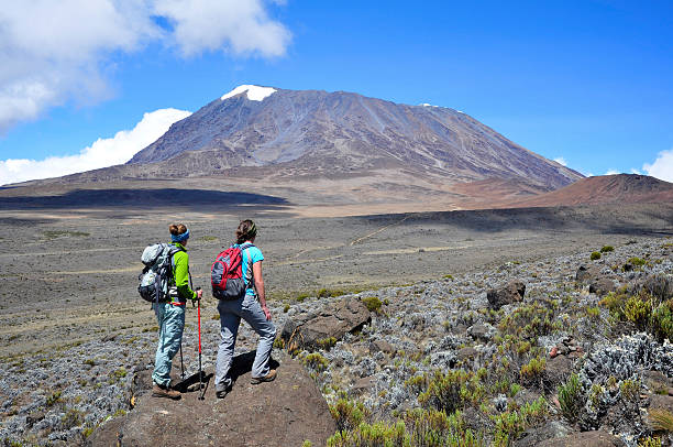 Two women overlook the Marangu Route in Mount Kilimanjaro National Park Tanzania.